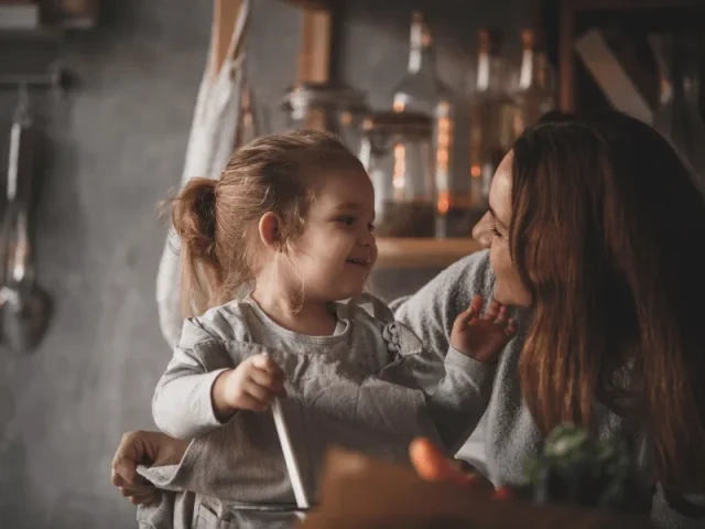 Madre abrazada con su hija pequeña, imagen del taller sobre el comienzo de escuelitas y colegios
