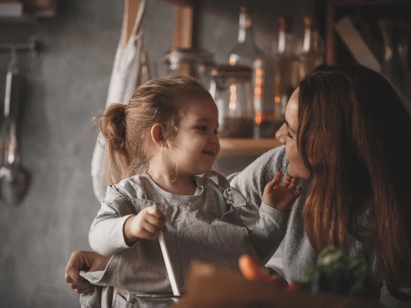 Madre abrazada con su hija pequeña, imagen del taller sobre el comienzo de escuelitas y colegios